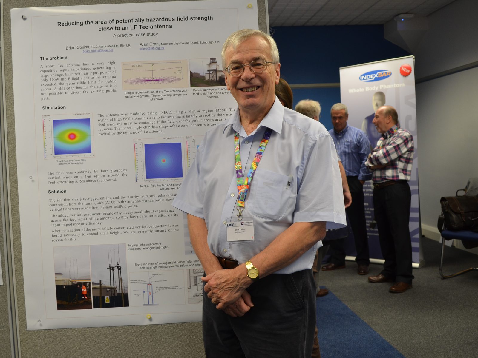 Brian Collins beside his conference poster on reducing hazardous field strength near an LF Tee antenna